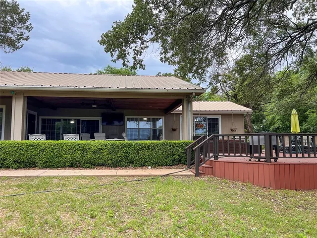 a view of a house with swimming pool and chairs
