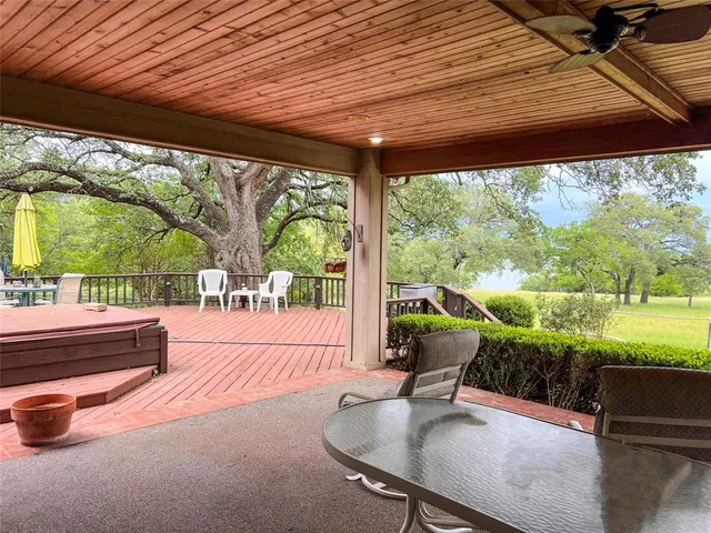 a patio with table and chairs and potted plants