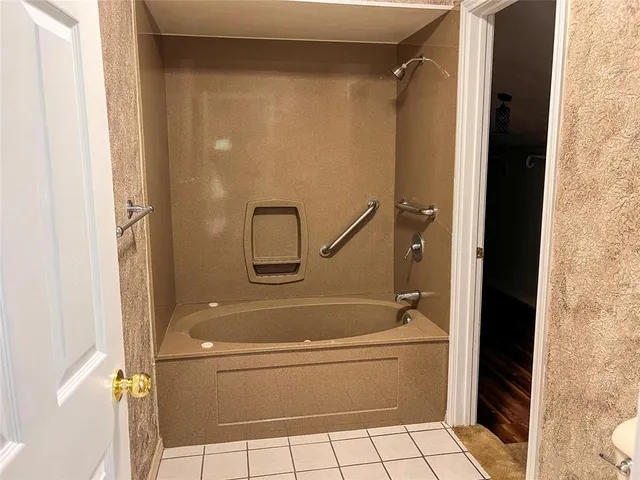 a bathroom with a granite countertop bathtub shower and toilet