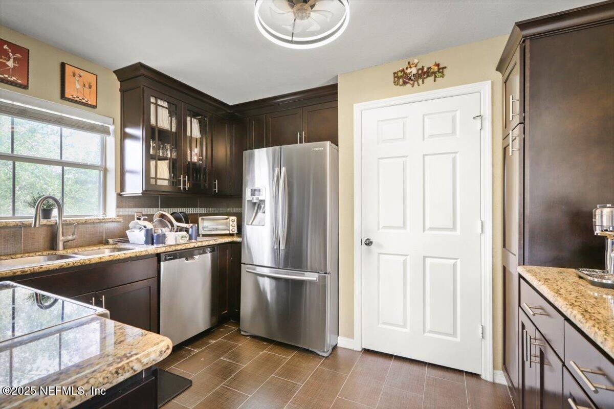 10961 Burnt Mill Road, Unit 1132 Jacksonville, FL 32256 - Photo 17 of 47 a kitchen with stainless steel appliances granite countertop a refrigerator and a sink