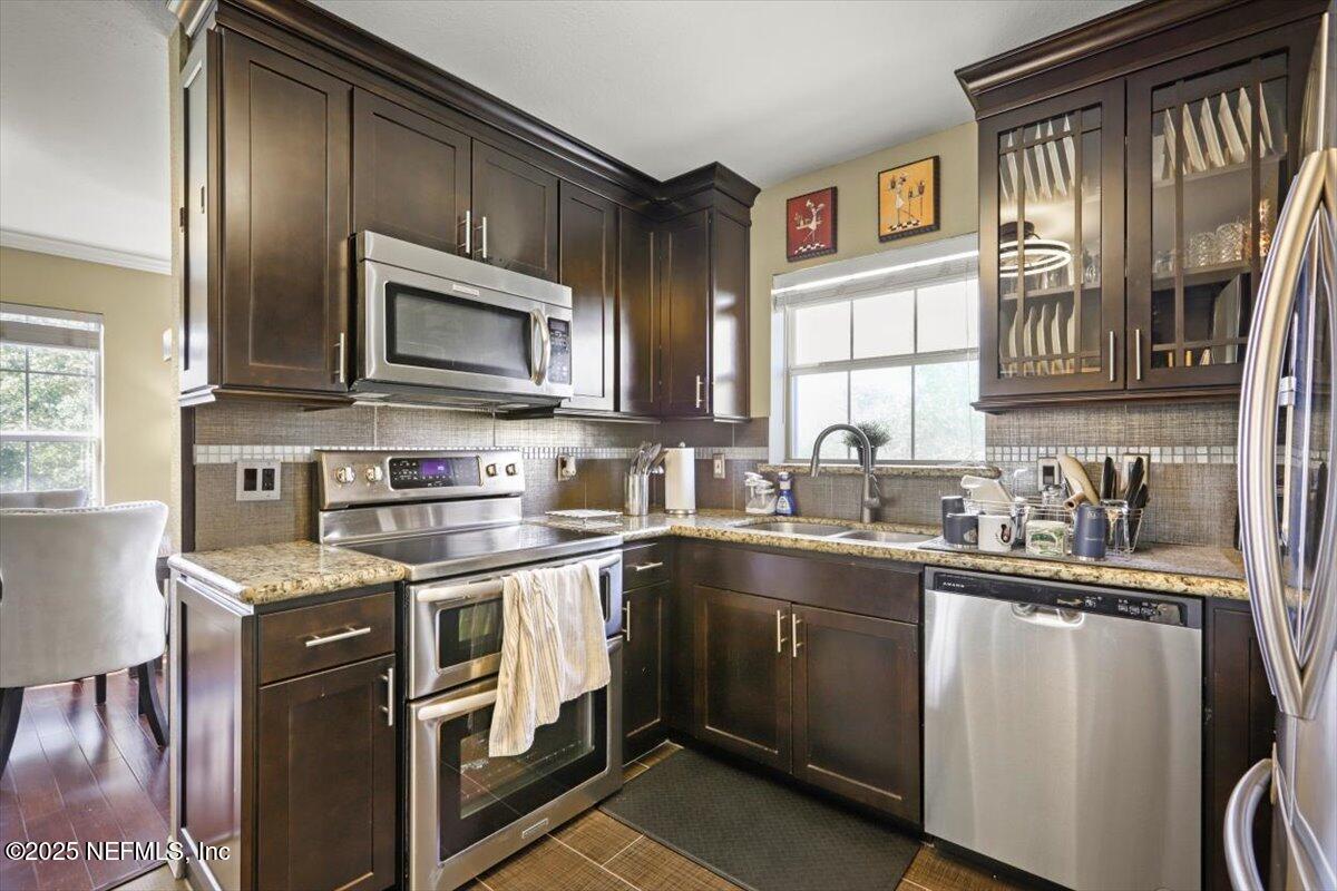 10961 Burnt Mill Road, Unit 1132 Jacksonville, FL 32256 - Photo 18 of 47 a kitchen with stainless steel appliances granite countertop a sink stove refrigerator and cabinets