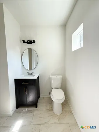 a bathroom with a toilet and a mirror