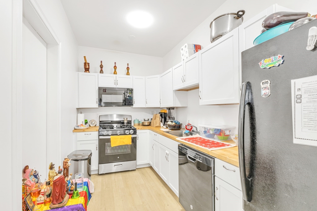 36 Brookledge Street Boston, MA 02121 - Photo 6 of 31 a kitchen with stainless steel appliances a stove a sink and a refrigerator