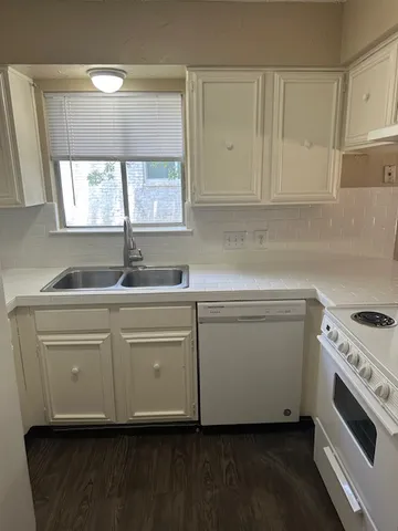 a kitchen with granite countertop white cabinets and a sink