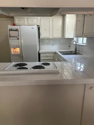 a kitchen with a refrigerator and a sink