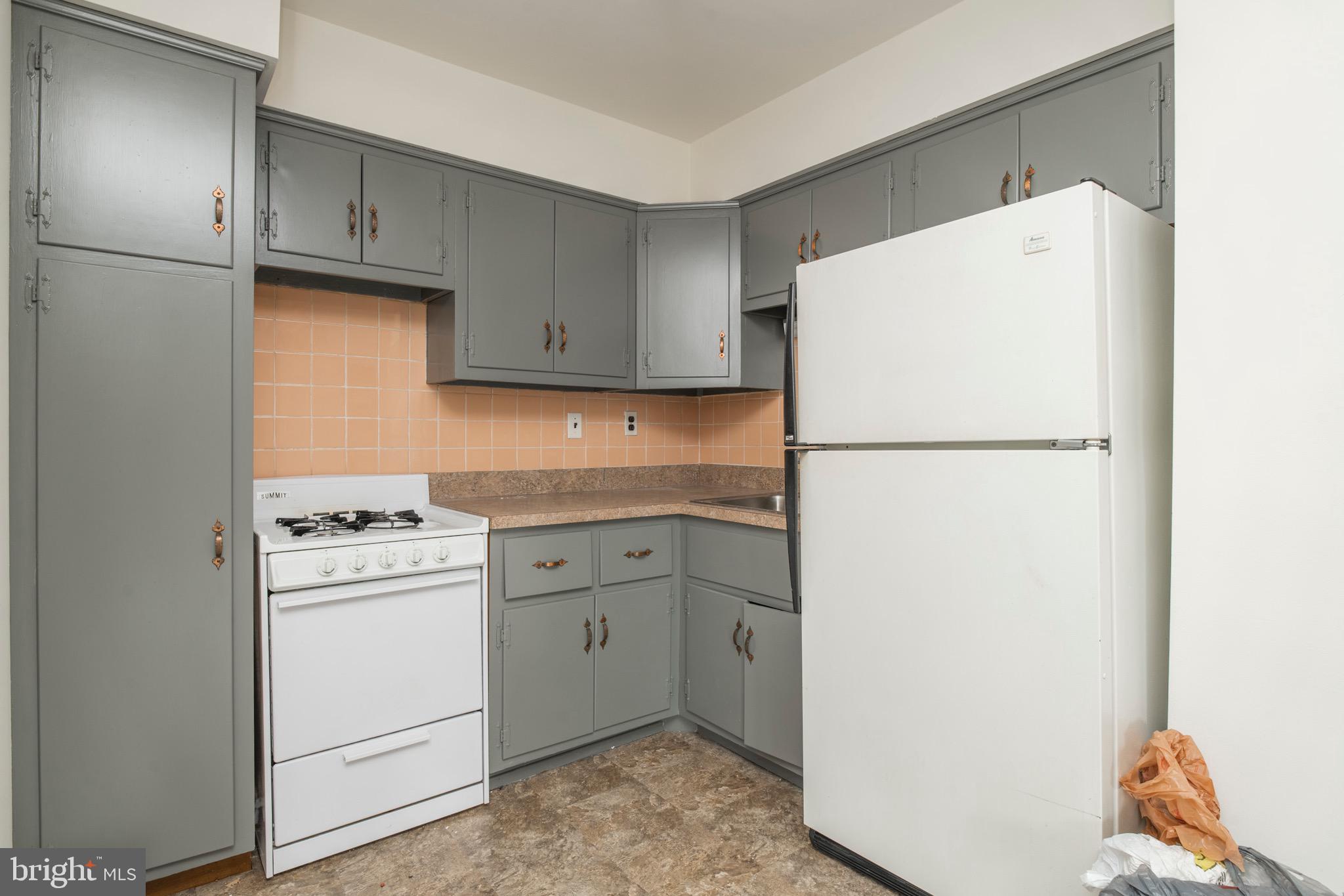 2730 Cranston Road Philadelphia, PA 19131 - Photo 12 of 25 a kitchen with a refrigerator sink stove and cabinets