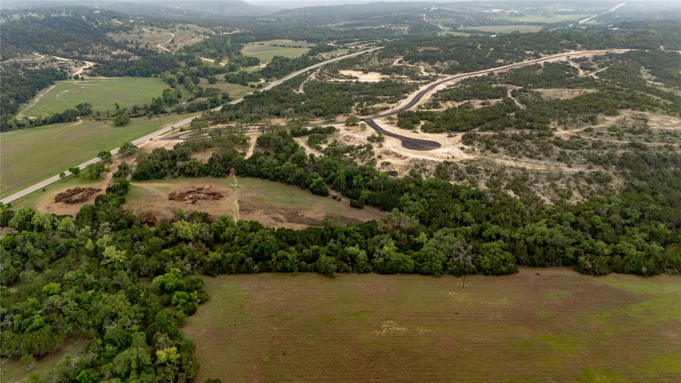 Lot 26 Ranch Road 165 Dripping Springs, TX 78620 - Photo 6 of 13 Expansive rural landscape featuring extensive tree cover, open fields, and a paved road network