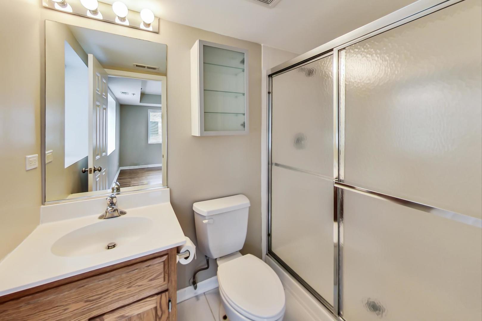 7326 40th Street, Unit 4D Lyons, IL 60534 - Photo 11 of 22 a white toilet sitting next to a bathroom sink