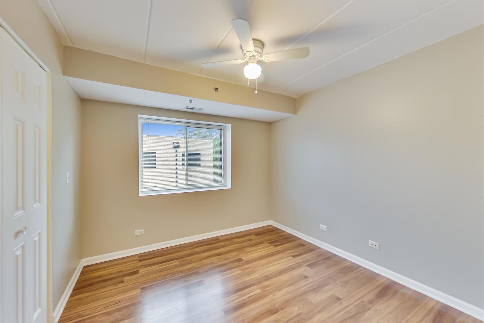7326 40th Street, Unit 4D Lyons, IL 60534 - Photo 13 of 22 a view of an empty room with wooden floor and a window