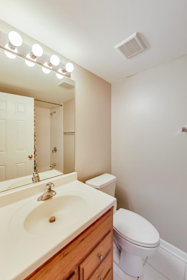 7326 40th Street, Unit 4D Lyons, IL 60534 - Photo 16 of 22 a bathroom with a sink a toilet and mirror