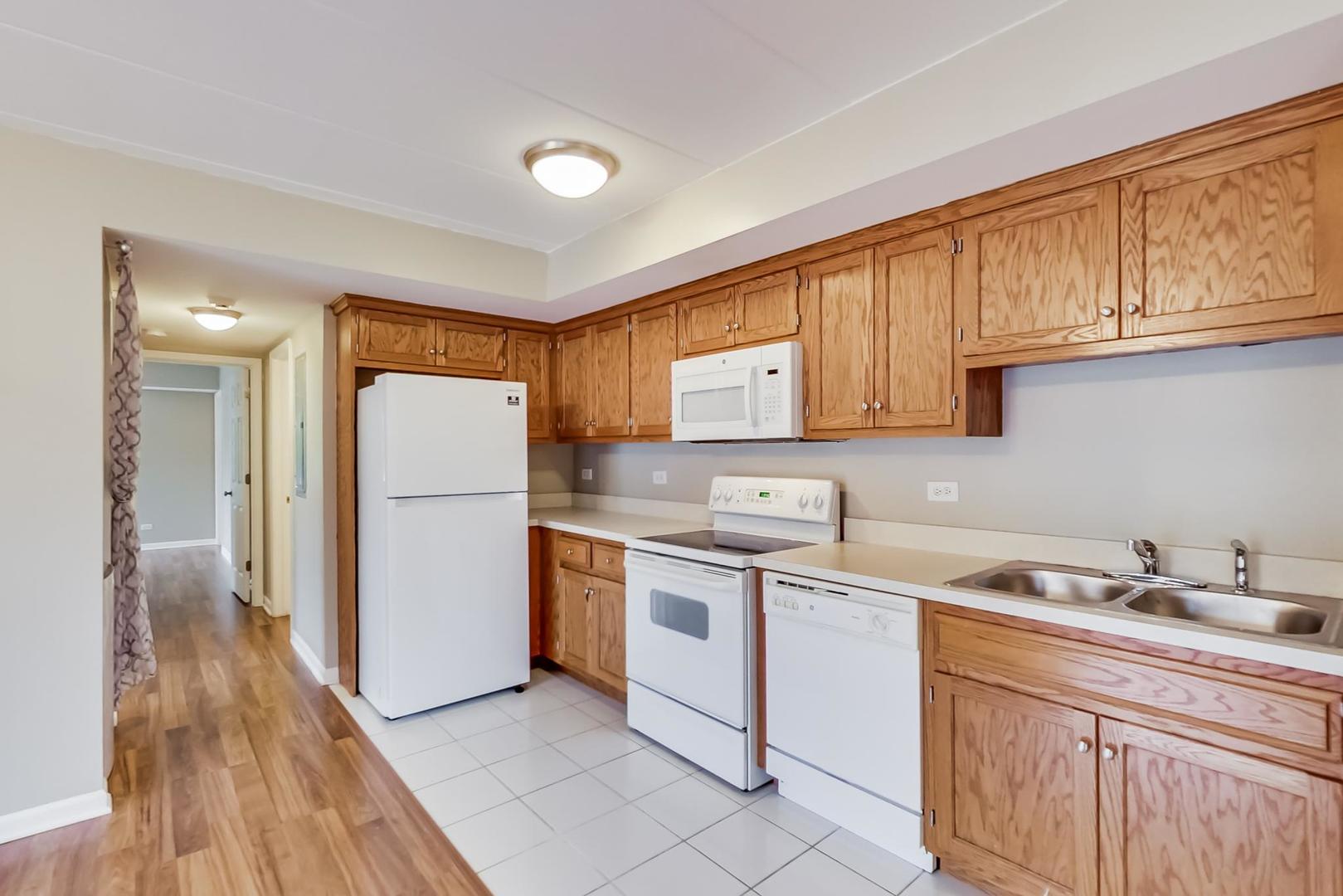 7326 40th Street, Unit 4D Lyons, IL 60534 - Photo 7 of 22 a kitchen with a sink a refrigerator and cabinets