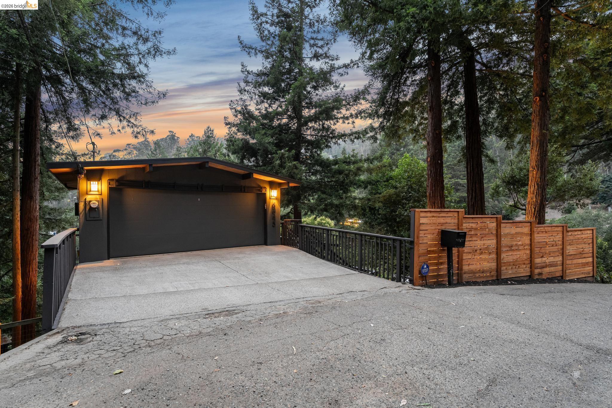 6645 Heather Ridge Way Oakland, CA 94611 - Photo 1 of 61 Carport entrance featuring a dark-toned garage door and two exterior sconce lights