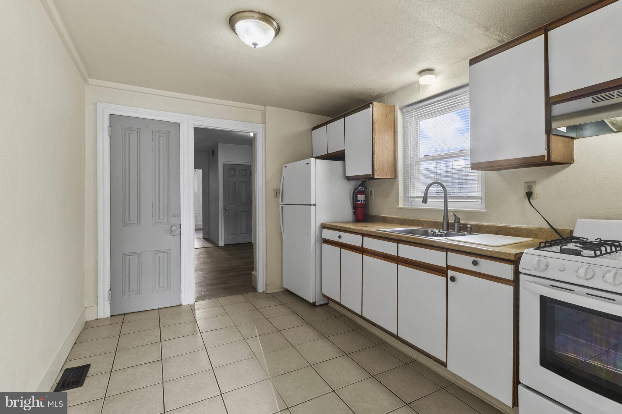 516 Kohn Street Norristown, PA 19401 - Photo 12 of 28 a kitchen with granite countertop a sink stove and cabinets