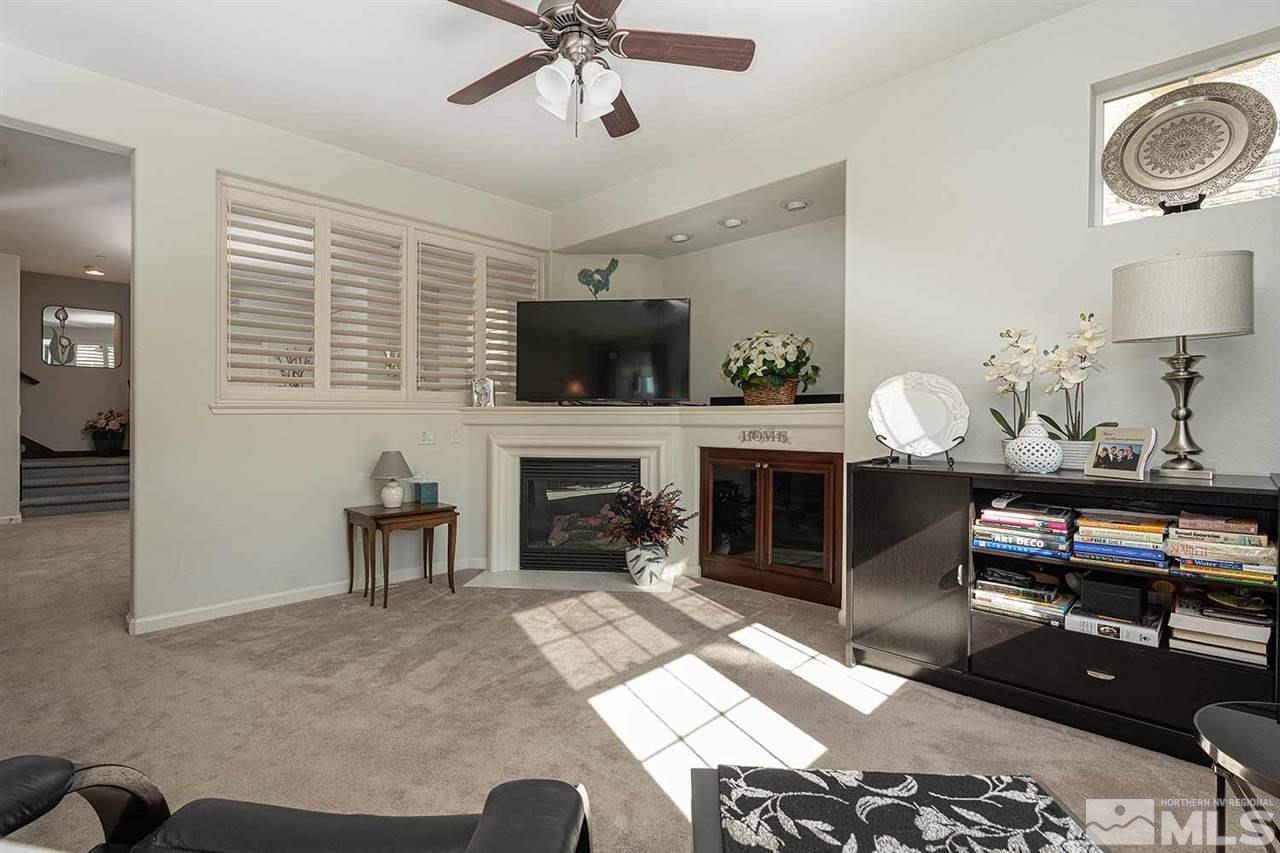 1775 Wind Ranch Road, Unit A Reno, NV 89521 - Photo 8 of 25 a living room with furniture a fireplace and a flat screen tv