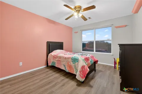 a bedroom with a bed window and flat screen tv