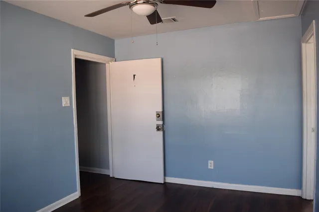 an empty room with wooden floor and cabinet