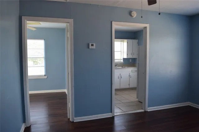 an empty room and a gallery with wooden floor