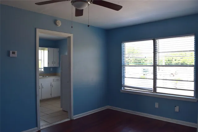 an empty room with a window and wooden floor