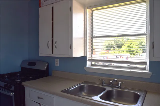 a kitchen with a sink cabinets and a window