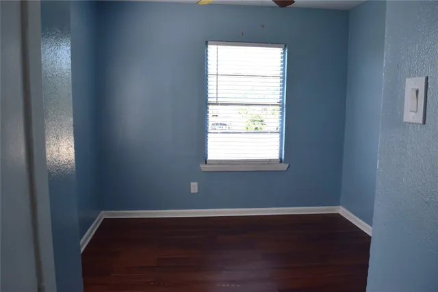 a view of a room with wooden floor and windows