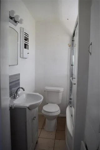 a bathroom with a toilet a sink and mirror