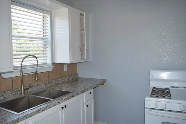 a kitchen with granite countertop a sink and cabinets