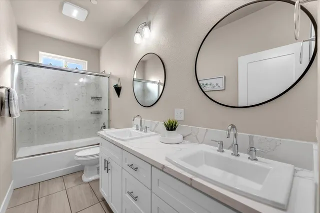 a bathroom with a double vanity sink mirror and toilet