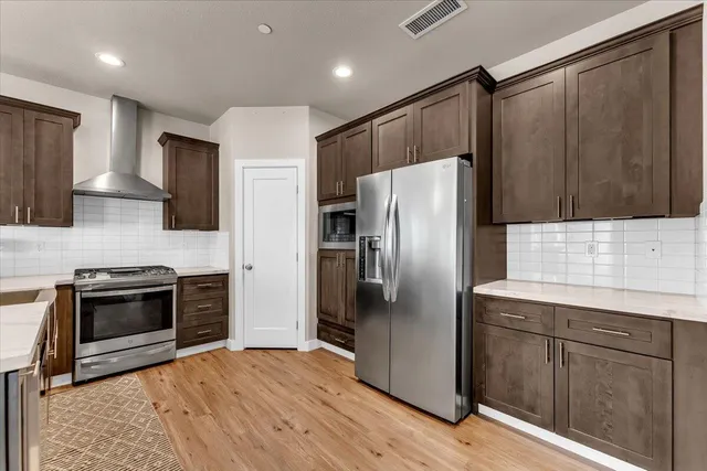 a kitchen with stainless steel appliances granite countertop a refrigerator stove and sink