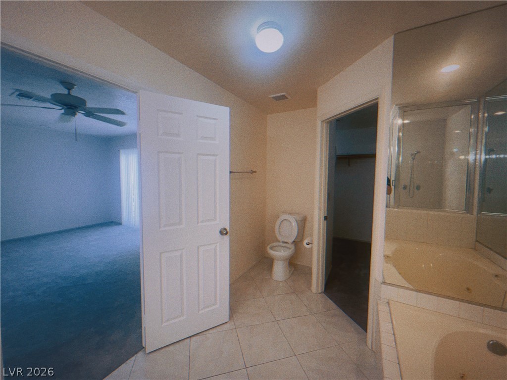 6250 West Flamingo Road, Unit 60 Las Vegas, NV 89103 - Photo 19 of 23 This primary bathroom features a corner tub, separate shower, and tiled flooring, with an adjoining carpeted room visible.
