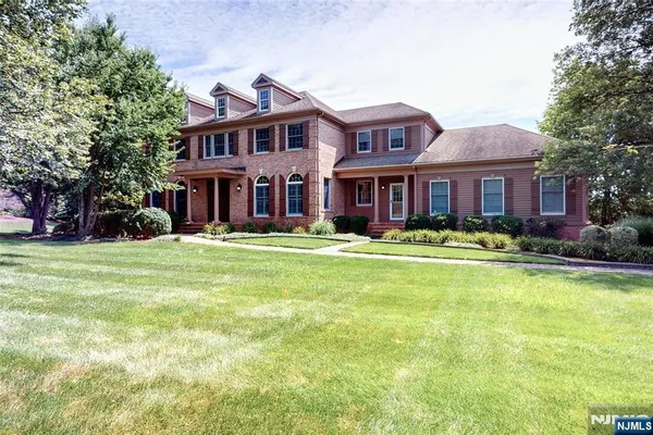 a front view of a house with swimming pool and green space