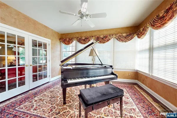 a living room with a piano a rug and a window