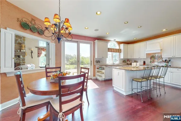 a view of a dining room with furniture a chandelier and wooden floor