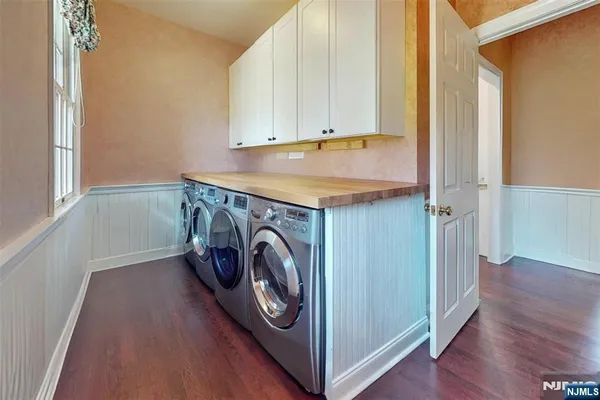 a utility room with wooden floor washer and dryer