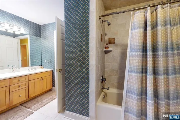 a bathroom with a double vanity sink a toilet and shower