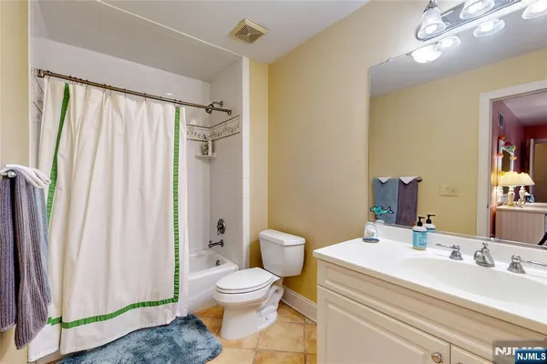 a bathroom with a sink a toilet and shower curtain