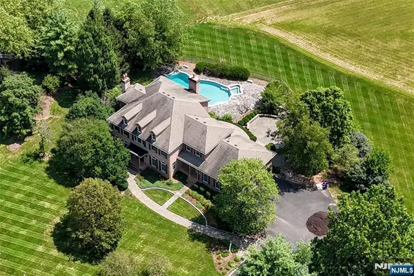 an aerial view of a house with a garden and lake view