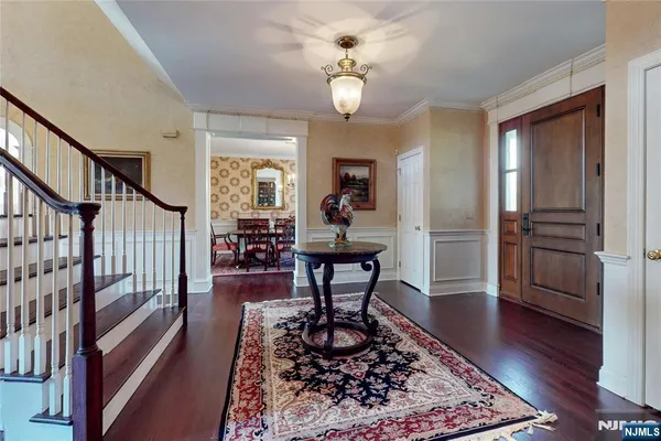 a living room with wooden floor furniture and a chandelier