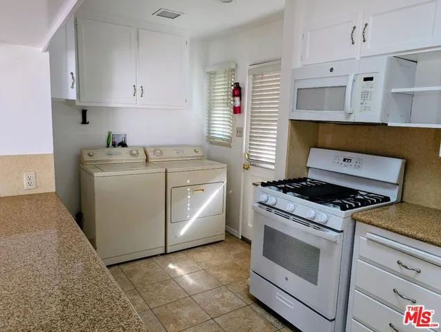 a kitchen with white cabinets and white appliances