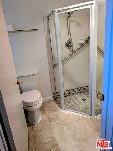 a bathroom with a toilet and a shower