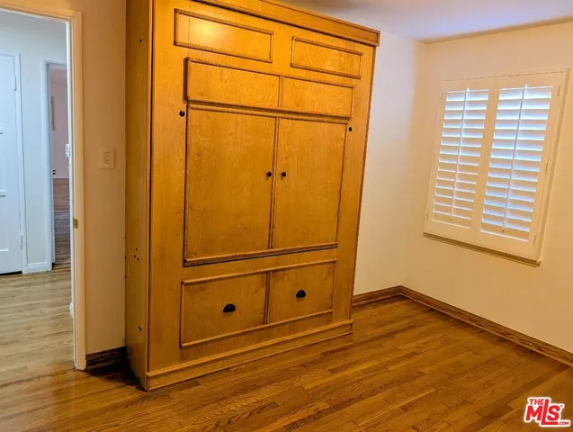 a view of a closet area with wooden floor