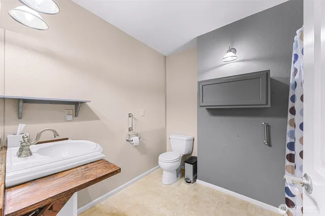 a bathroom with a toilet a sink and mirror