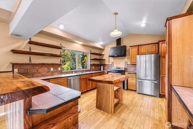 a kitchen with stainless steel appliances granite countertop a sink and a wooden cabinets