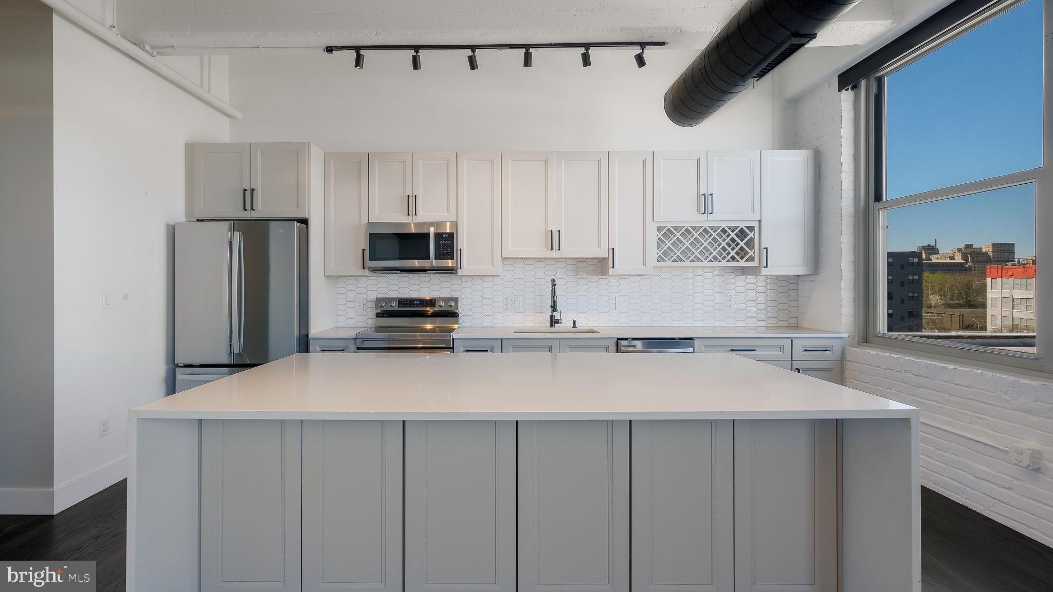444 North 4th Street, Unit 601 Philadelphia, PA 19123 - Photo 5 of 38 a kitchen with stainless steel appliances a refrigerator sink and white cabinets
