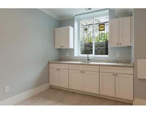 93 Pond Brook Road Newton, MA 02467 - Photo 31 of 33 a kitchen with granite countertop white cabinets and a window