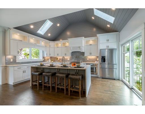 93 Pond Brook Road Newton, MA 02467 - Photo 9 of 33 a kitchen with stainless steel appliances kitchen island granite countertop a table chairs and a refrigerator