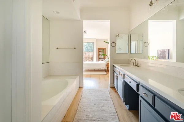 a spacious bathroom with a tub double vanity sink and a mirror