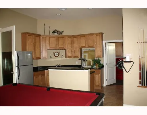 a kitchen with stainless steel appliances granite countertop a refrigerator a stove and a sink