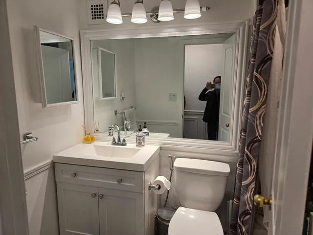 a bathroom with a toilet sink and mirror