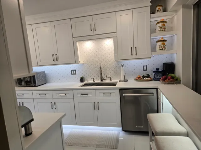 a kitchen with cabinets appliances and furniture