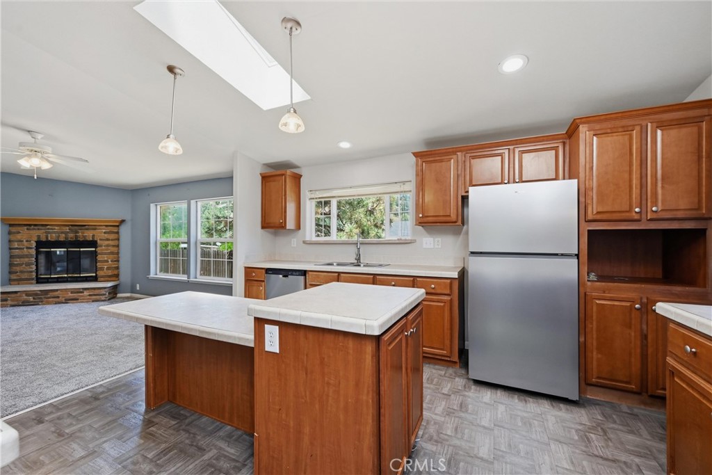 2860 Spring Valley Road Clearlake Oaks, CA 95423 - Photo 18 of 38 a kitchen with granite countertop stainless steel appliances a refrigerator a stove top oven a sink dishwasher and wooden cabinets
